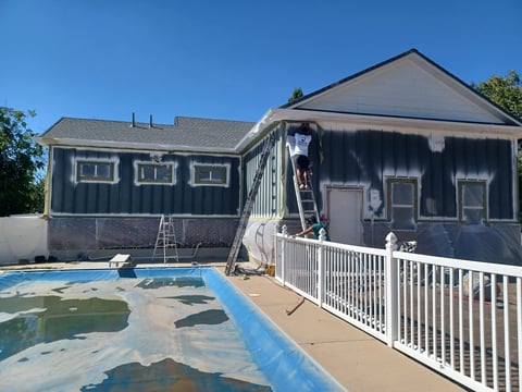 House exterior with in-ground pool renovation and white railings under construction on a sunny day
